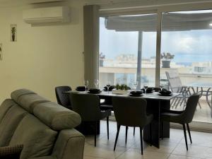 a dining room with a table and a couch at Eva's Penthouse with private Swimming pool by ELDI in Il-Gżira