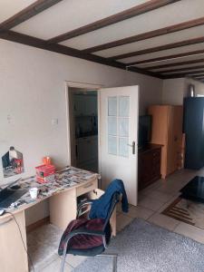 a room with a desk and a table and a door at Brothers Homestay in Best