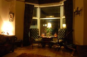 a living room with a table and chairs and a window at The Leicester in Southport