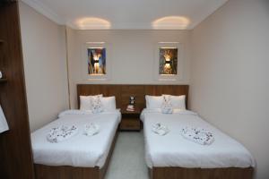 two beds in a hotel room with white sheets at Sacred Pyramids Stay in Cairo