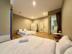 a hotel room with two beds and a mirror at The Modern Nest in Ban Bang Chan