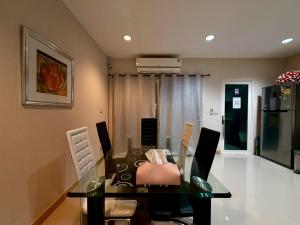 a dining room with a glass table and chairs at The Modern Nest in Ban Bang Chan +9 photos