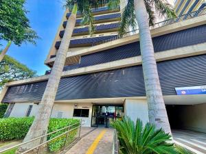 a building with palm trees in front of it at Maxplaza Residential 1209 in Canoas