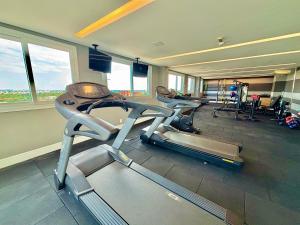 a gym with two treadmills in a room with windows at Maxplaza Residential 1209 in Canoas