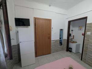a room with a door and a television on a wall at Angel Room 2 in Nea Plagia