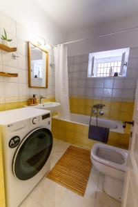 a bathroom with a toilet and a washing machine in it at BougainVilla in Vonitsa +28 photos