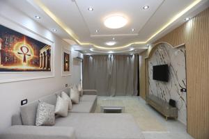 a living room with a couch and a tv at Sacred Pyramids Stay in Cairo