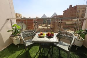 a table with a bowl of fruit on a balcony at Sacred Pyramids Stay in Cairo
