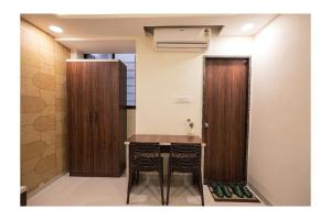 a room with a table and a wooden door at Hotel Venus Inn in Indore