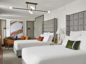 a hotel room with two beds and a desk at 21c Museum Hotel St Louis in Saint Louis