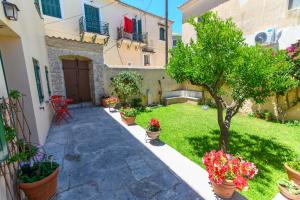 a courtyard of a house with potted plants and a tree at BougainVilla in Vonitsa