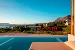 a view from the living room of a house with a swimming pool at Sunset View Paleros - Boutique Suites in Paleros