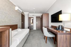 a hotel room with a bed and a desk at Hotel Weneda in Opole