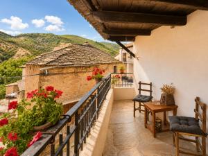 a balcony of a house with red flowers on it at Casa Rural Pablo in Ara