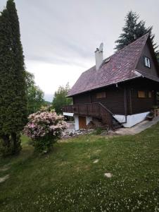 a large wooden house with a roof on a field at Chata Radostín in Radostín