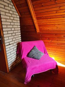 a bed with a pink blanket in a cabin at Chata Radostín in Radostín