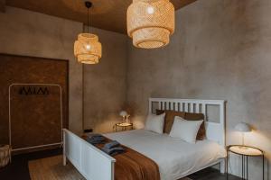 a bedroom with a white bed with two lights and two lamps at Buntes nams l Self check-in l Private entrance in Limbaži