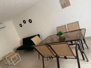 a dining room with a glass table and chairs at Marina Diamante - Ilse C in Acapulco