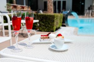 a table with two wine glasses and a plate of food at Metsikas Residence in Limenas