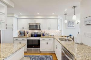 a kitchen with white cabinets and stainless steel appliances at Sea Colony - 604 Dover House Rd. in Bethany Beach
