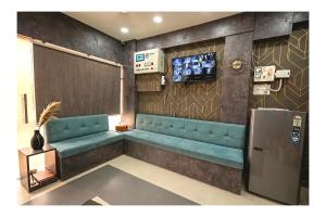 a waiting room with blue seats and a tv at Hotel Venus Inn in Indore