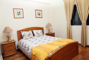 a bedroom with a bed and two lamps and a window at JP Alojamento Local in Ponta Delgada
