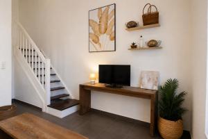 a living room with a television on a table with a staircase at Côté Golf Marina in Saint-François