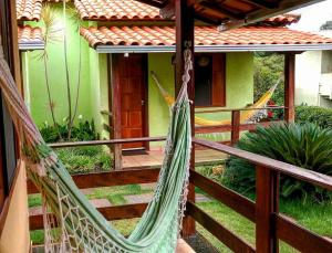 a porch with a hammock in front of a house at Pousada Licuri in Serra do Cipo