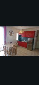 a kitchen with a table and chairs and red cabinets at Casse blanche in Orcières