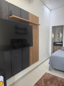 a bedroom with a bed and a tv on a wall at Loft bem localizado na cidade! in Boa Vista