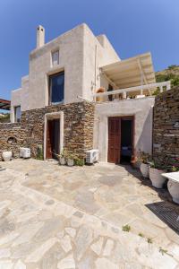a house with a stone patio in front of it at Pasithea Sunset in Milopótamos