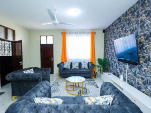 a living room with two couches and a tv at Serene Coastal Suites in Mombasa