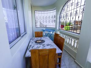 a small table and chairs in a room with windows at Serene Coastal Suites in Mombasa +10 photos
