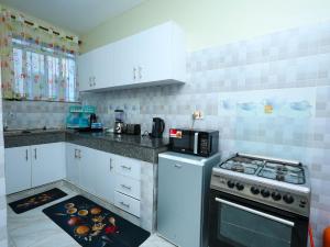 a kitchen with white cabinets and a stove top oven at Serene Coastal Suites in Mombasa
