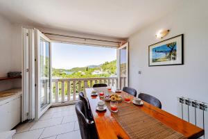 a dining room with a table and chairs and a balcony at Rezidence Castello in Korčula