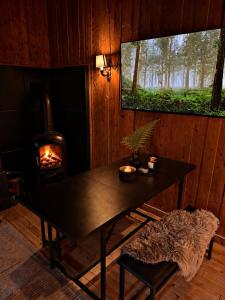 a dining room with a table and a fireplace at Forest Cabin by the Water in Ålesund
