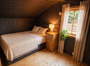 a small bedroom with a bed and a window at Forest Cabin by the Water in Ålesund