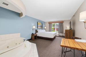 a hotel room with a bed and a bath tub at The Commerce, Trademark Collection by Wyndham in River Falls +26 photos