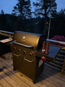 a grill sitting on a table on a deck at Forest Cabin by the Water in Ålesund