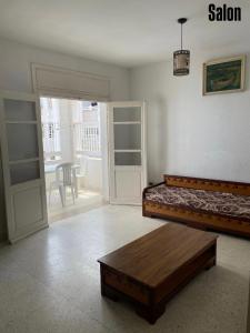 a bedroom with a bed and a wooden coffee table at Appartement S3 in Mahdia in Mahdia