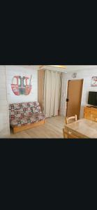 a room with two beds and a table and a television at Casse blanche in Orcières +1 photo
