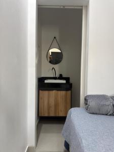a bathroom with a sink and a mirror at Loft bem localizado na cidade! in Boa Vista