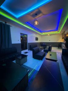 a living room with blue and green lights at Leebwill Hotel & Apartment in Eku