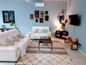a living room with two white couches and a table at Villa DOUDOU in Somone