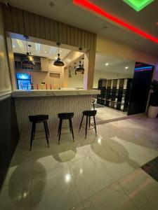 a bar with three chairs and a counter in a restaurant at Leebwill Hotel & Apartment in Eku +5 photos