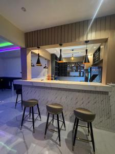 a bar with three stools and a counter in a restaurant at Leebwill Hotel & Apartment in Eku