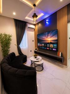 a living room with a couch and a flat screen tv at Leebwill Hotel & Apartment in Eku