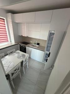a small kitchen with a table and a sink at C&A Apartment in Giroc