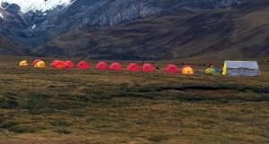 a group of tents in a field with mountains in the background at Selena Camping in Tayapampa