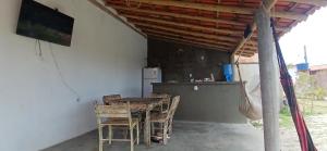 a dining room with a table and chairs and a refrigerator at Suíte Adam 1 em Caraíva com piscina 900m da Vila in Caraíva
